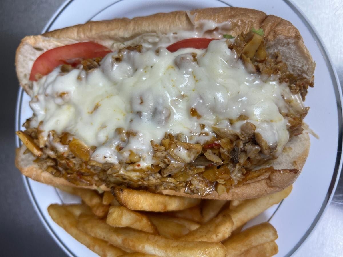 Chicken Philly sub with melted cheese and tomato, fries on the side