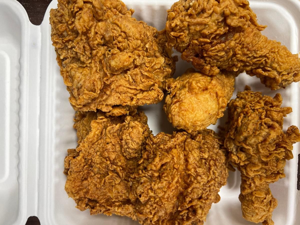 Crispy fried chicken legs and thighs in a takeout box