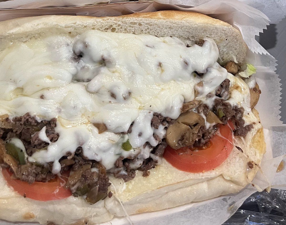 Philly steak sub with melted cheese, mushrooms and tomato